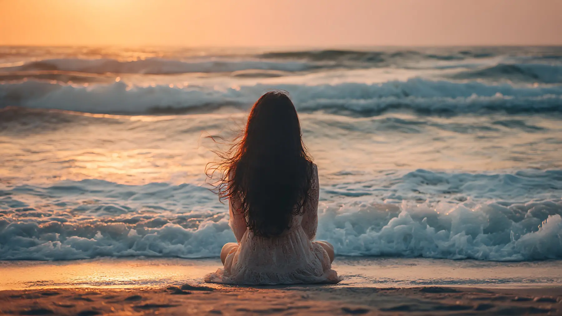 Woman sitting in stillness by the ocean at sunrise — representing mindful travel in North Myrtle Beach and the calm, reflective experience at Sea House Villas.