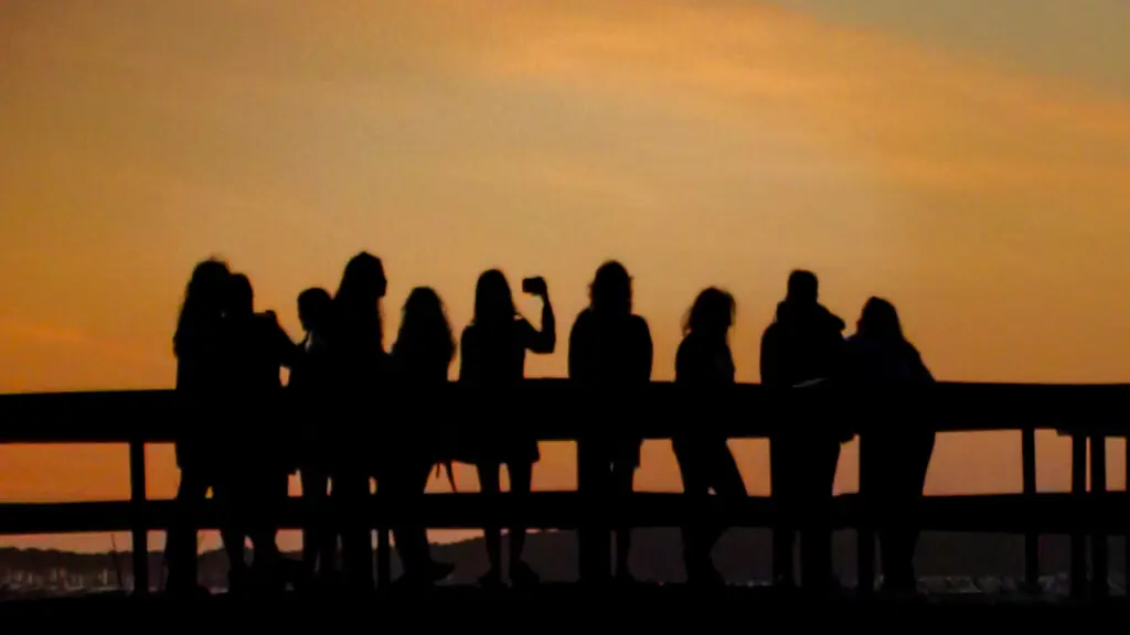 Group of friends enjoying a coastal sunset from a pier near Sea House Villas in North Myrtle Beach, South Carolina.