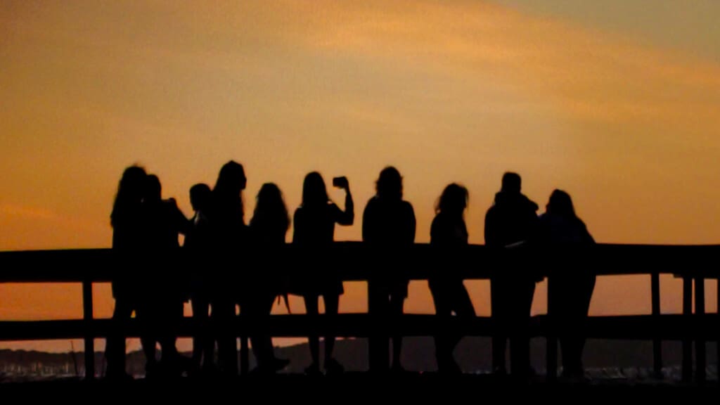 Group of friends enjoying a coastal sunset from a pier near Sea House Villas in North Myrtle Beach, South Carolina.